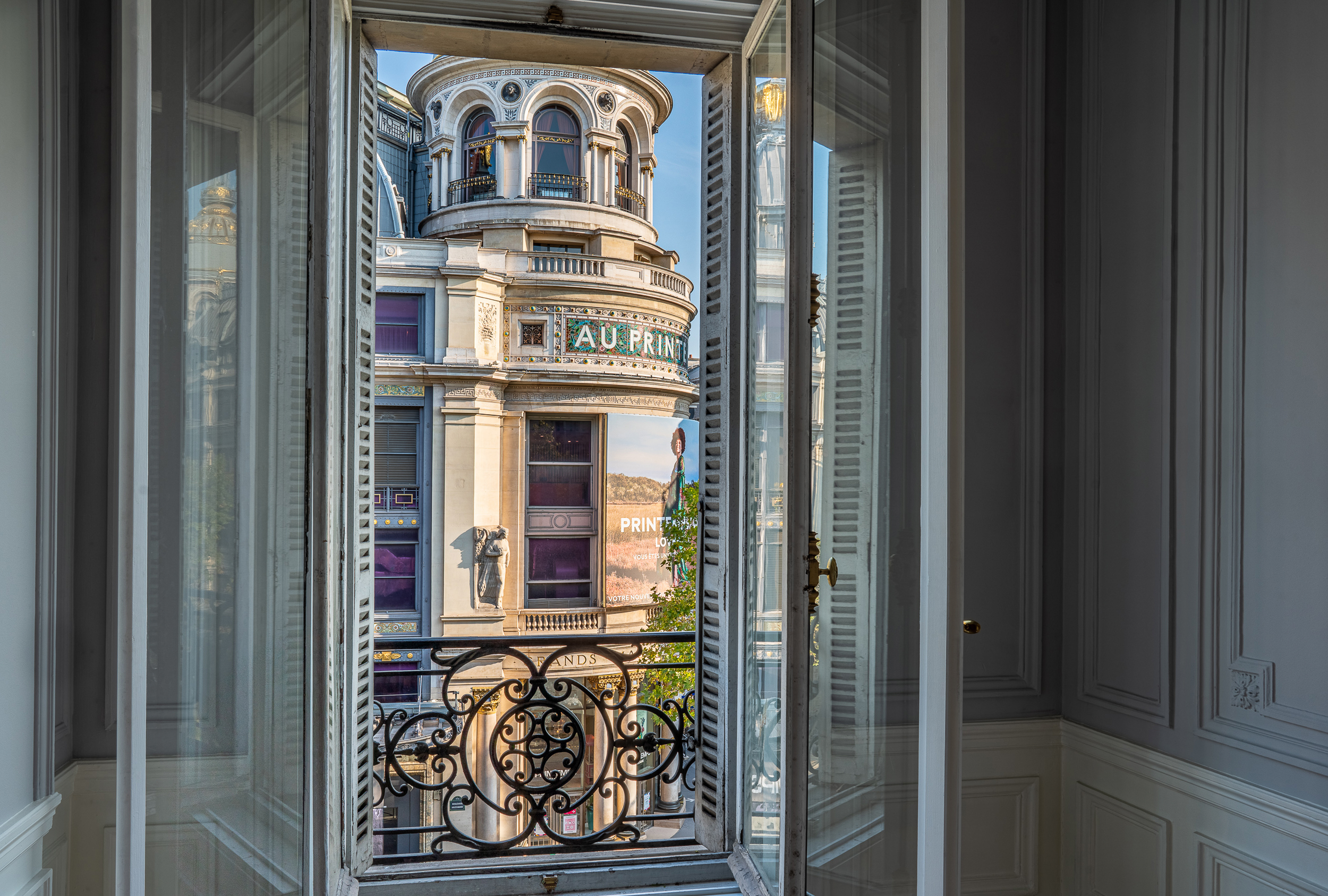 Fenêtre ouverte sur un grand boulevard parisien