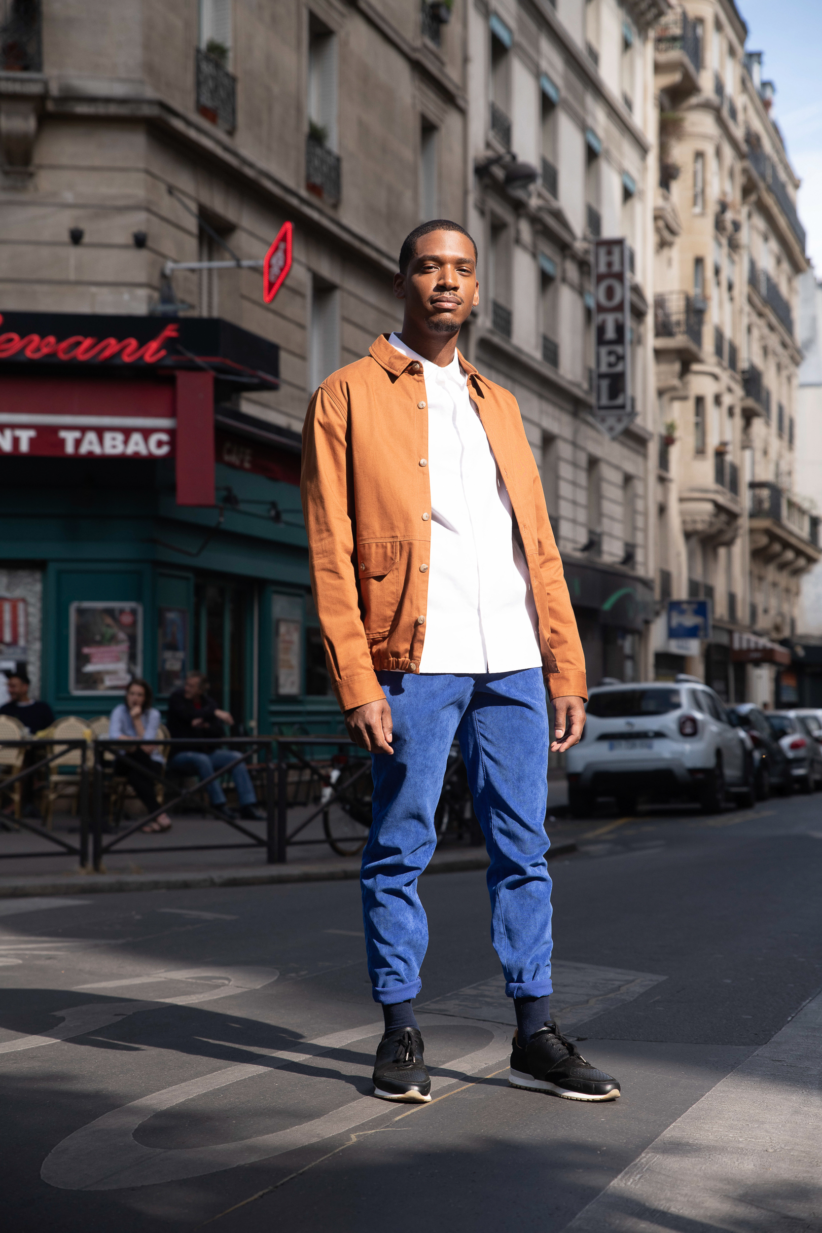 Homme portant une chemise blanche et un blouson brun ouvert